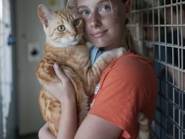 Jeune fille tenant un chat roux.